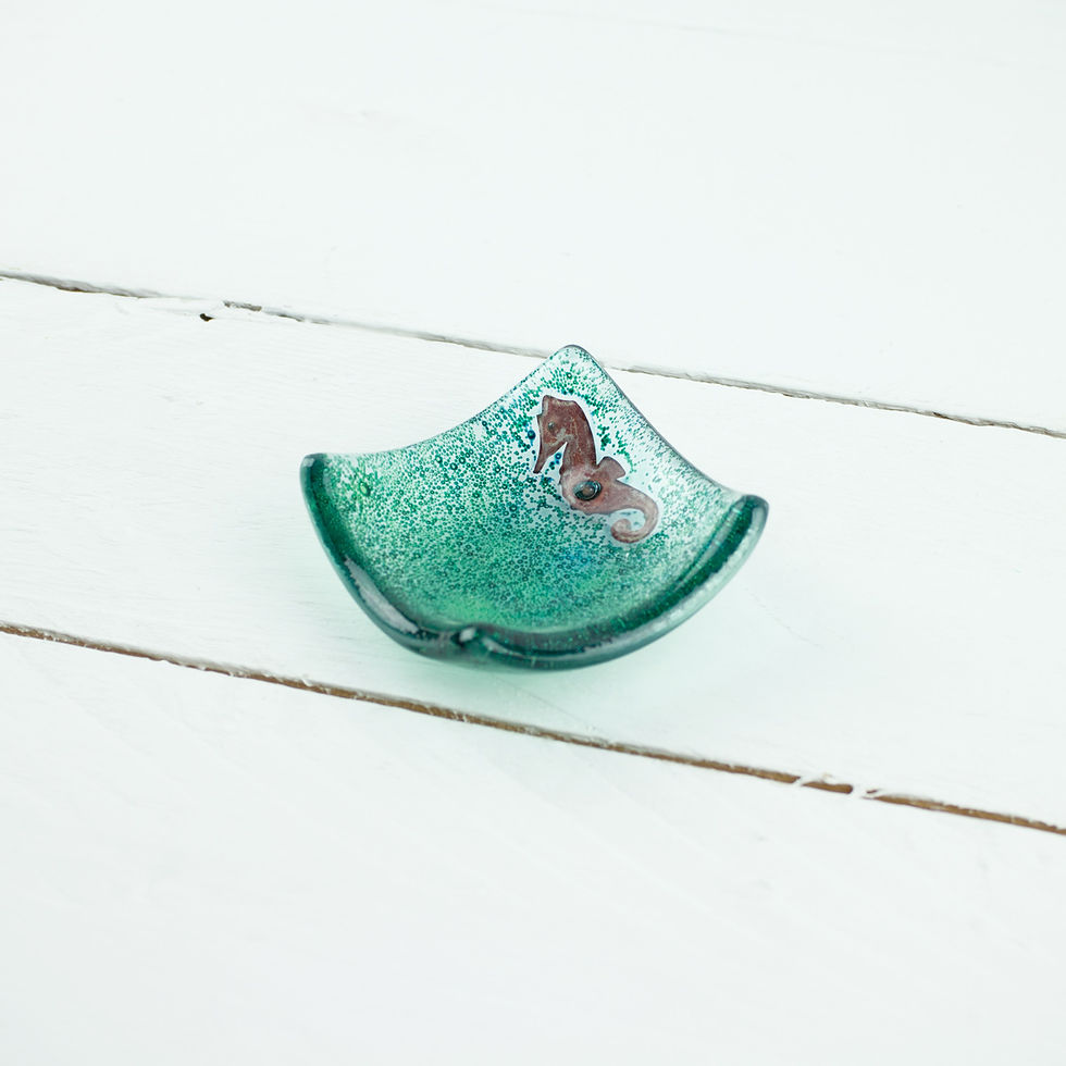Fused glass earring dish featuring a copper seahorse motif in a corner in a sea of bubbles.
