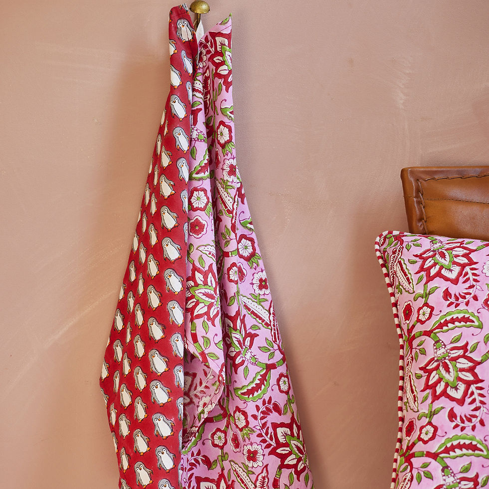 Thumbnail: Penguin Block Print Tea Towel Featuring repeat hand block printed penguins on a bright red backdrop hung from a hook.