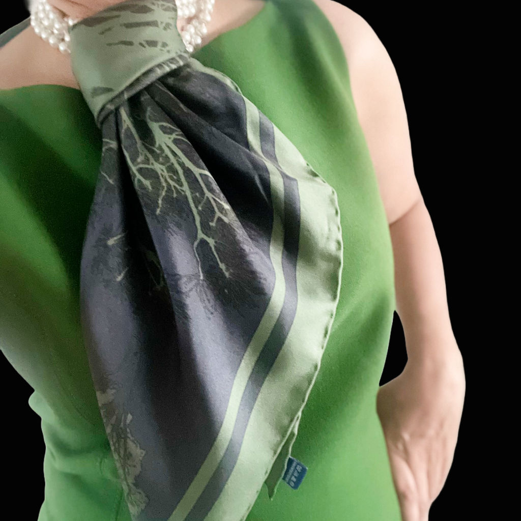 Square silk scarf featuring branches of a tree extending out from its centre, complemented on four corners by tree motifs .