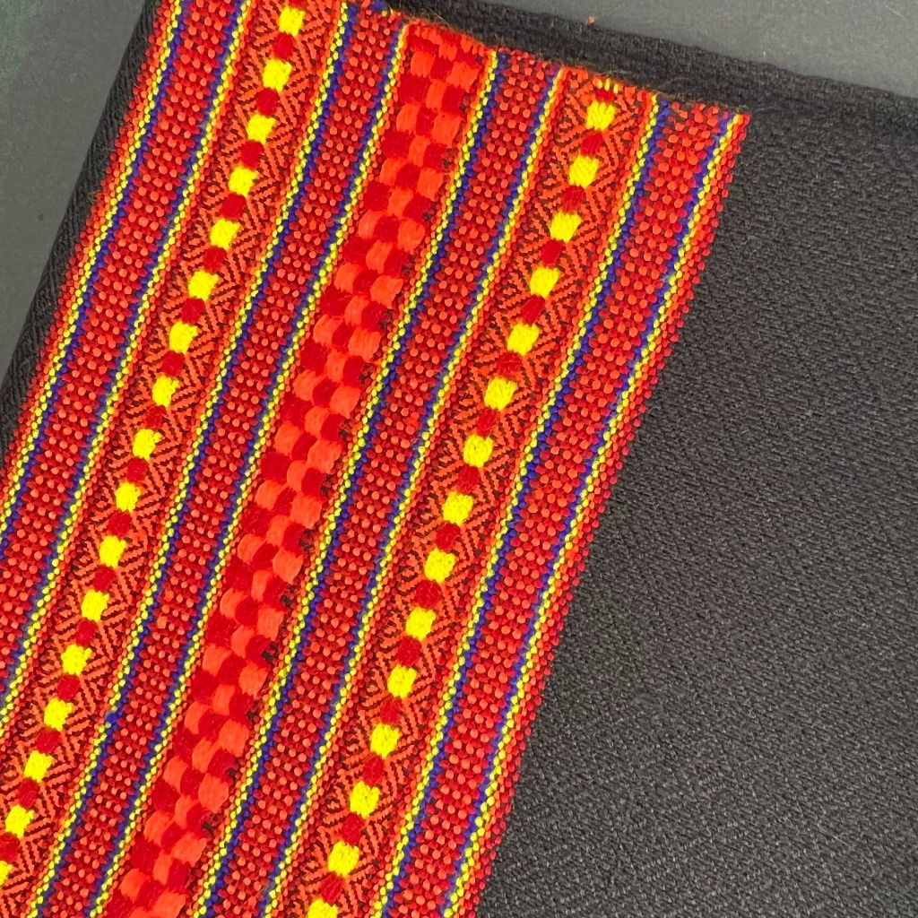 Handwoven Wool Scarf in Black with striped patterned orange/red/yellow border.