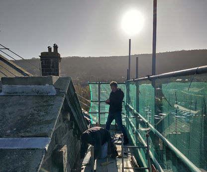 Roofers repairing some pointing