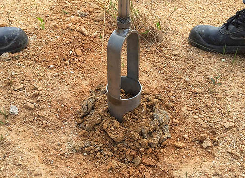 Hand auger drilling into soil for percolation testing