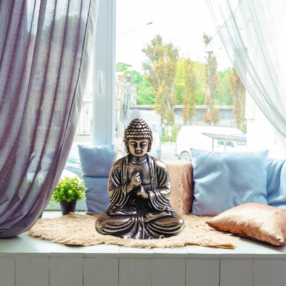 Boeddha beeld in rust, zittend voor een raam met gordijnen en kussens, Zen and So