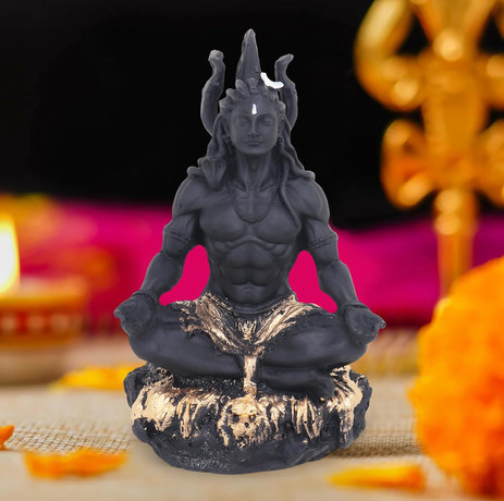 Zwarte Shiva beeld, mediterend. Gouden accenten en bloemen op tafel.
