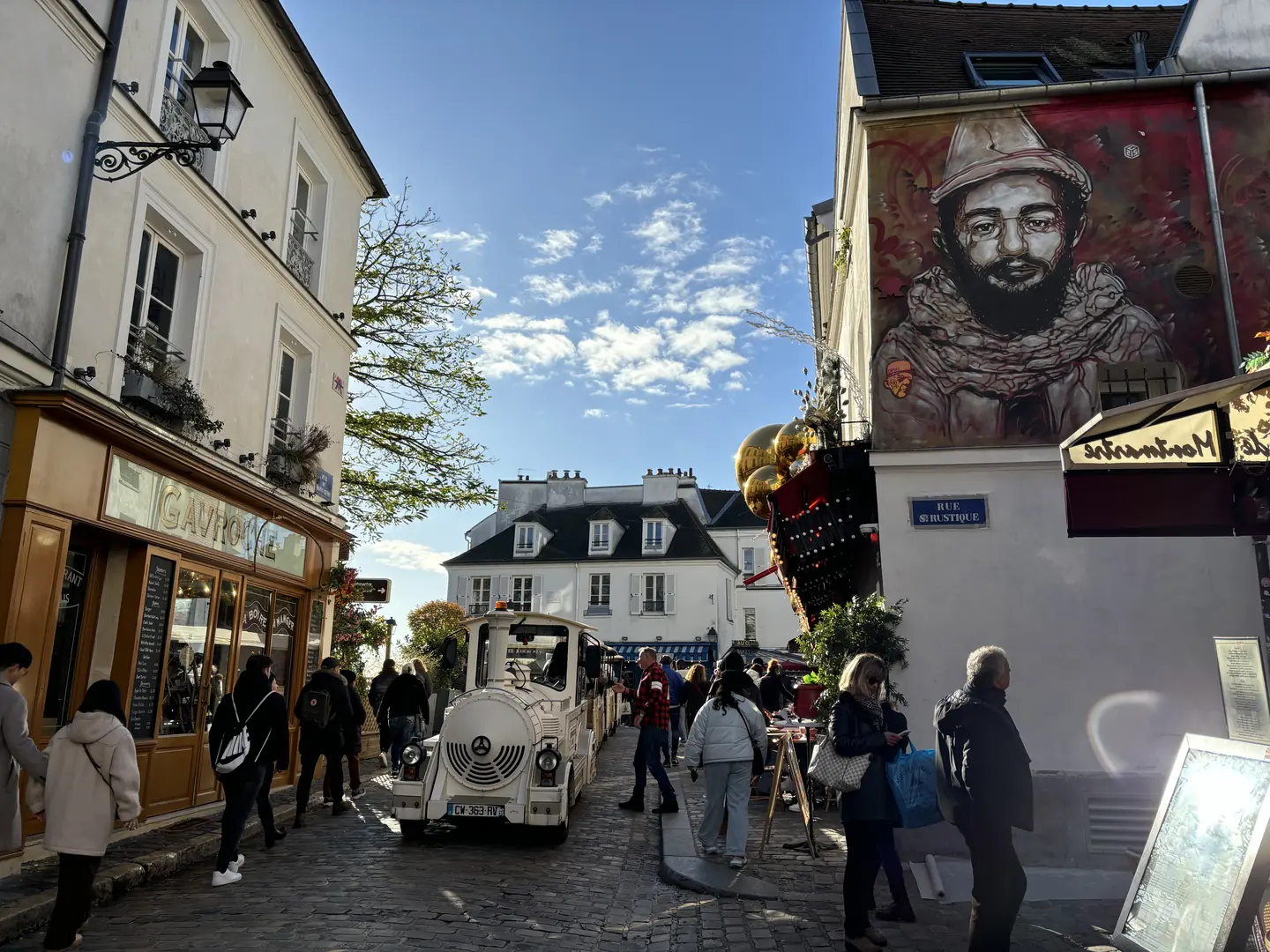 Charming Montmartre street with little tourist train and street art