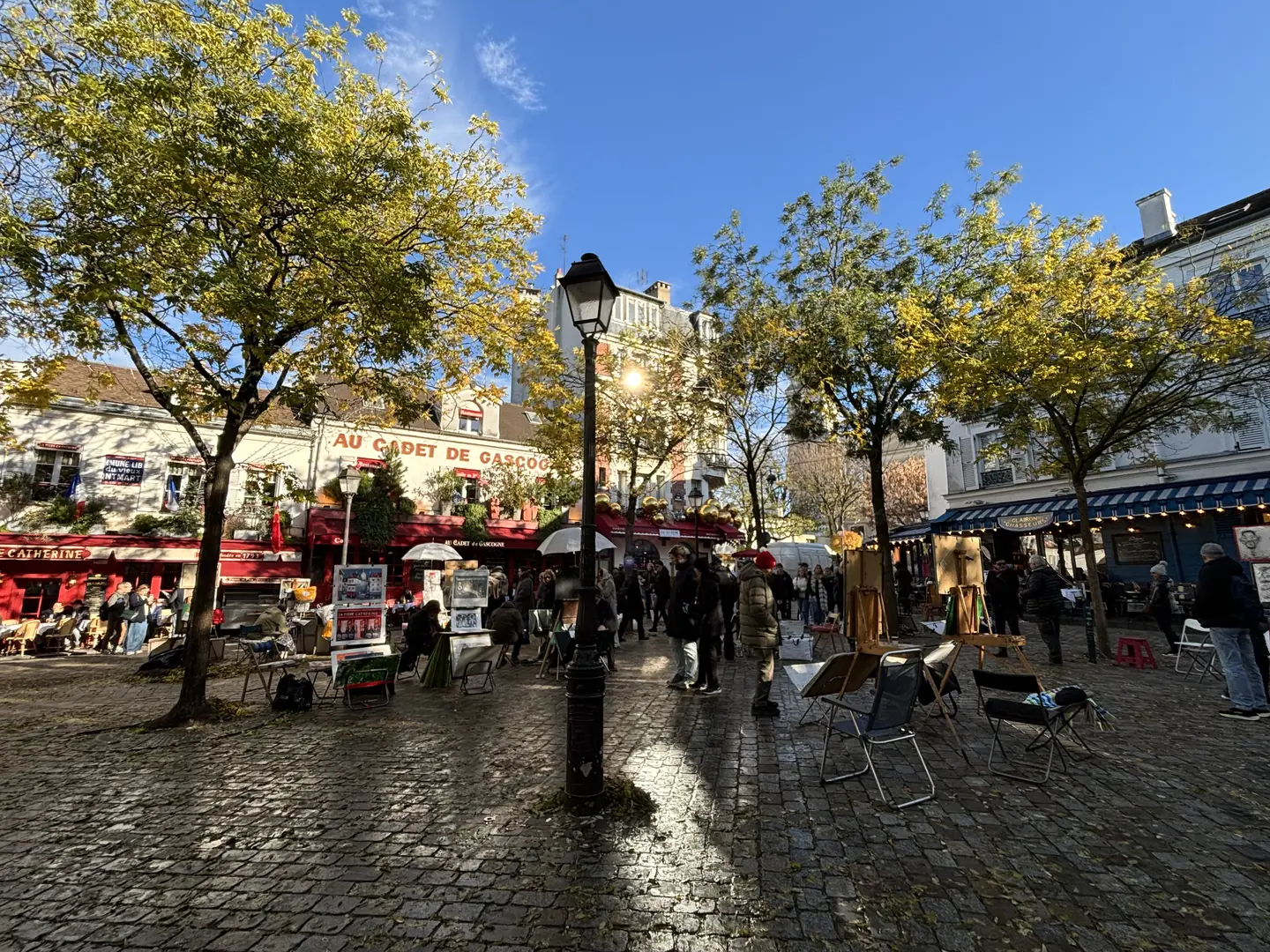 Place du Tertre with artists and cafés, final stop of Montmartre pastry tour