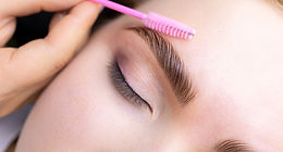 Brow and lash treatment showing eyebrow grooming with a precision brow brush