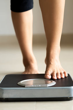Female-leg-stepping-on-weigh-scales.-Healthy-lifestyle,-food-and-sport-concept.-1169486621