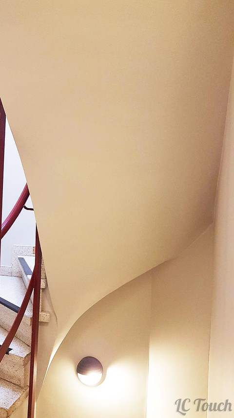 Détails de la cage d'escalier avec un éclairage et des murs arrondis.