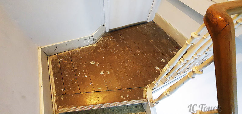 Palier d'escalier avec un parquet ancien et des balustres en bois nécessitant une rénovation, illustrant l'état de l'escalier avant les travaux.