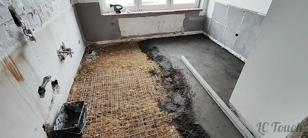 Application de la nouvelle chape sur treillis métallique après démolition pour la rénovation complète du sol de la cuisine.