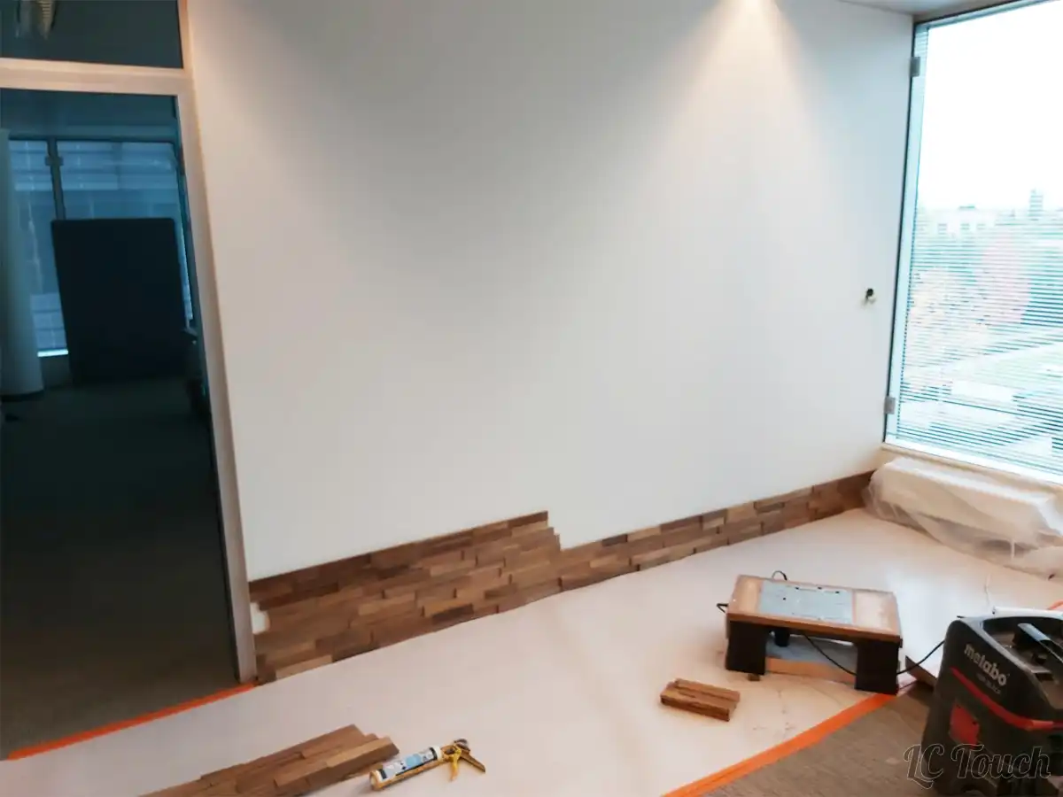 Début de la pose d’un parement mural en bois 3D dans un espace de bureaux