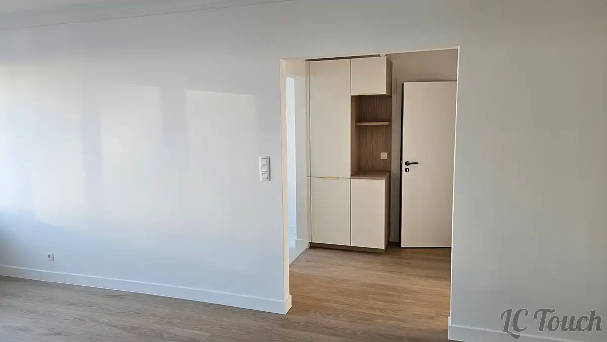 Salon rénové avec murs peints en blanc et nouveau mobilier intégré, sur un sol en vinyle imitation bois posé par LC Touch