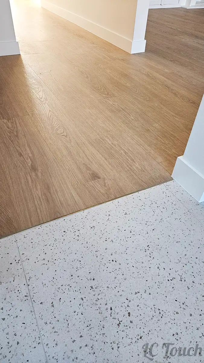 Transition soignée entre carrelage terrazzo et vinyle imitation bois après rénovation complète du sol
