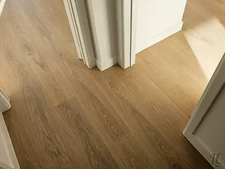 Sol en vinyle imitation bois récemment posé dans le couloir rénové d’un appartement à Bruxelles