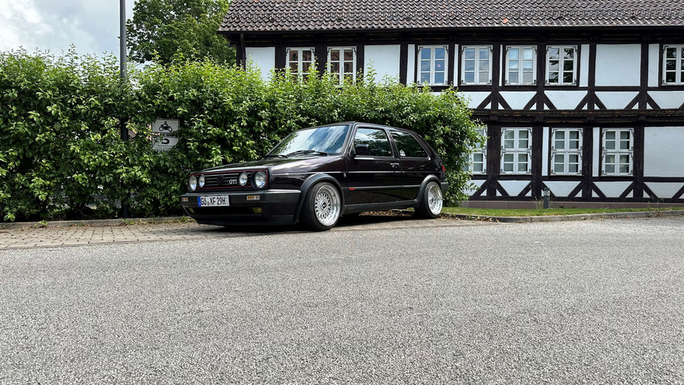 Dunkelroter VW Golf II vor Fachwerkhaus
