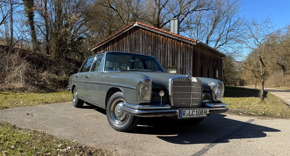 Grauer Mercedes-Benz W108, Einbecker Oldtimertage 2025, vor Holzhaus