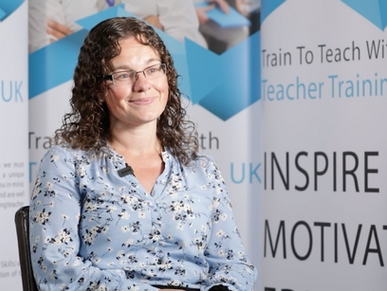Woman in blue floral blouse smiling, seated against "Train To Teach" banner with words Inspire, Motivate. Bright, professional setting.