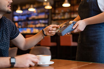 Young man paying for his coffee with a card