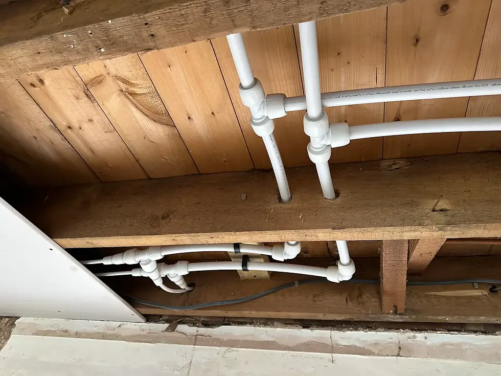 New plumbing pipe installation beneath timber floor joists in a St Albans property.