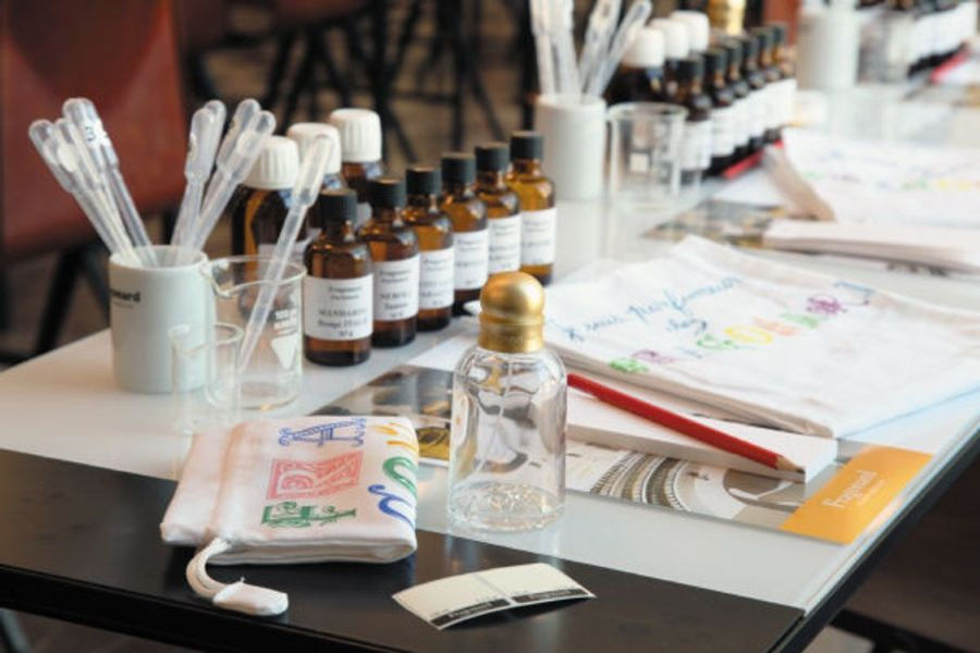 Table de découverte olfactive avec flacons et pipettes, initiation aux matières du parfum
