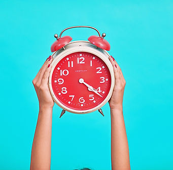 person holding red and beige twin bell analog alarm clock_edited.jpg