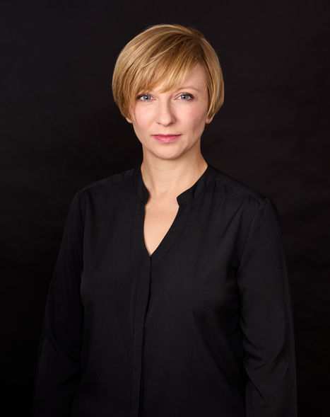 Serious Portrait of woman wearing black blouse, black backdrop