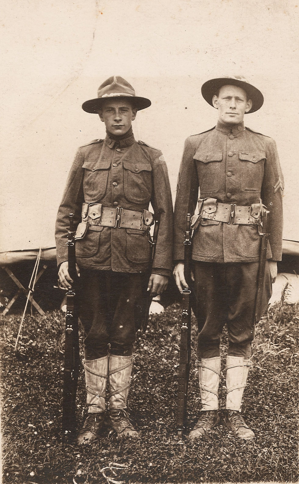 Picture of two American soldiers (aka "doughboys") in full military apparel, rifles at their sides.
