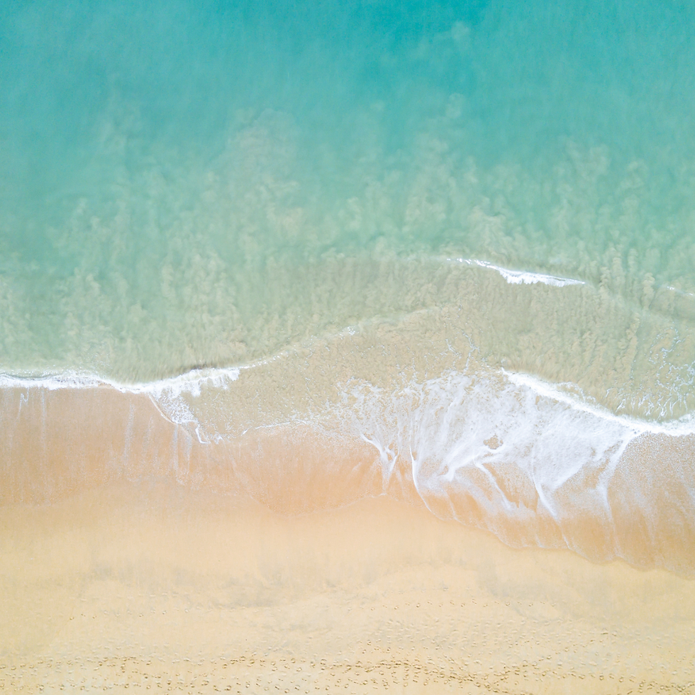 A peaceful ocean shoreline with gentle waves meeting the sand beneath a soft sunrise, representing calm, hope, and healing.