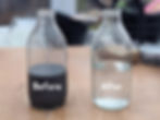 Two bottles of water on a table. The one on the right is labelled 'Before' and coloured black, the one on the left is labelled 'after' and is clear