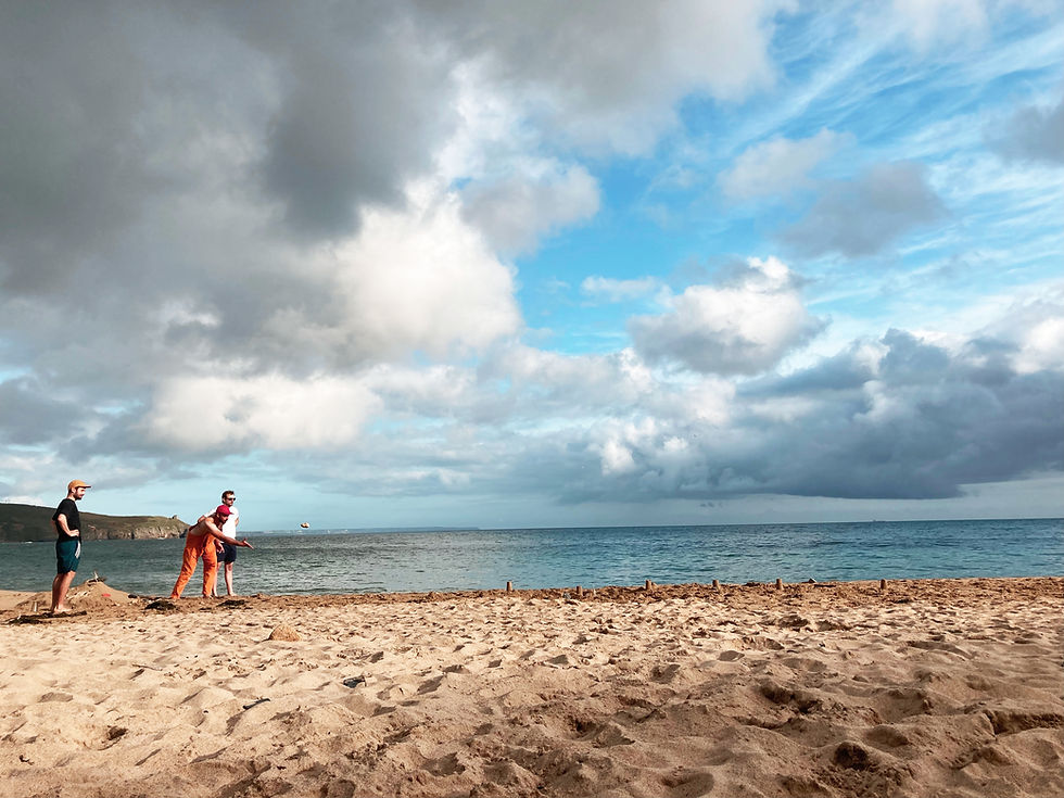 Friends playing a game at Praa Sands beach in Cornwall