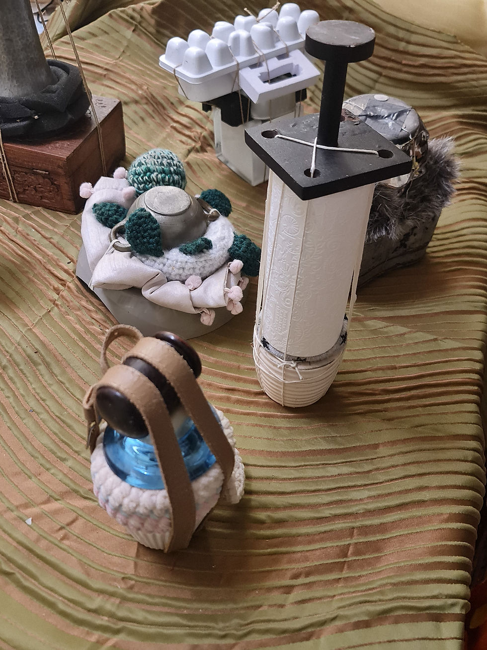 variety of small bound objects on with textile covered greenish ground