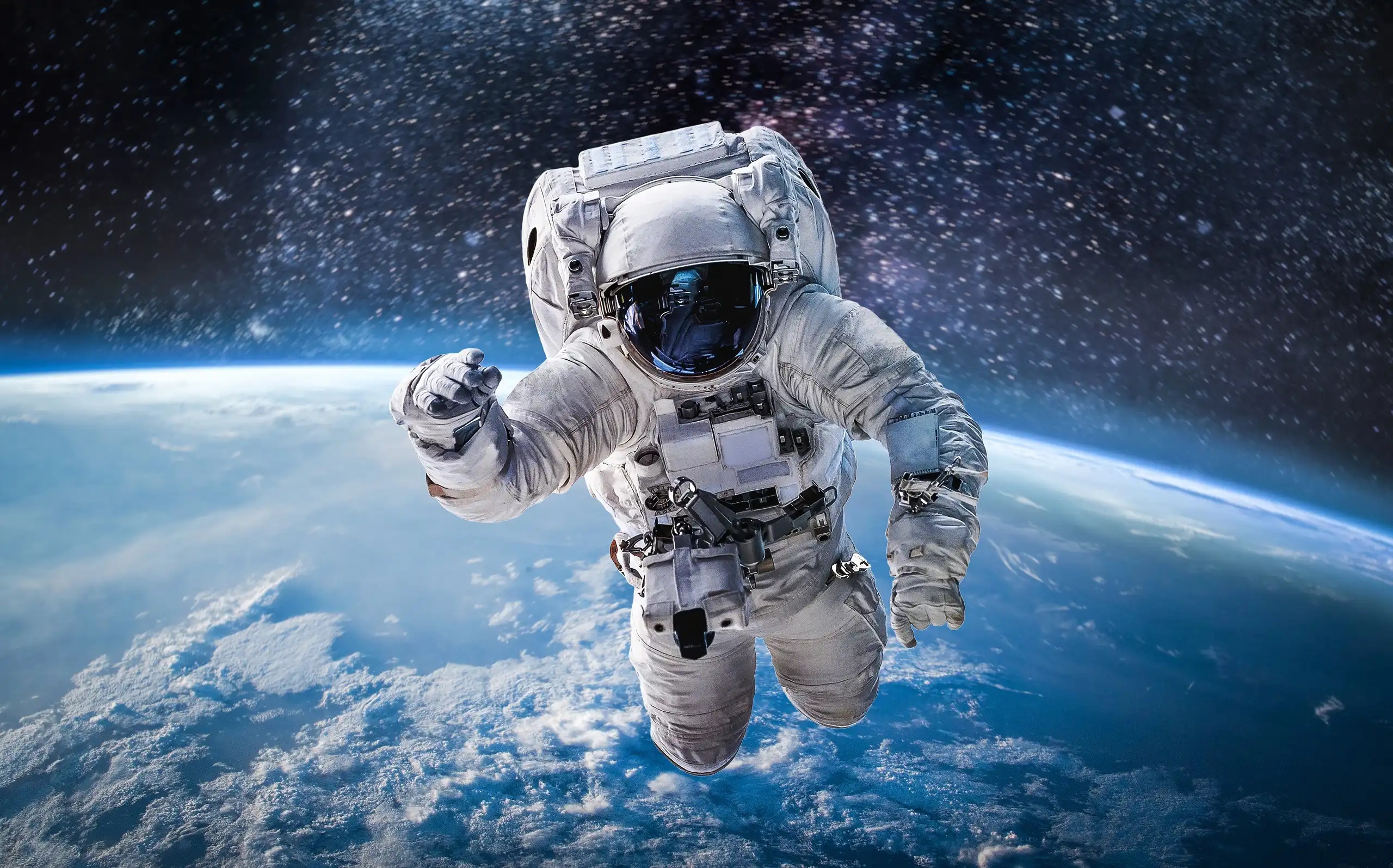 Astronaut in a spacesuit floating in open space above earth