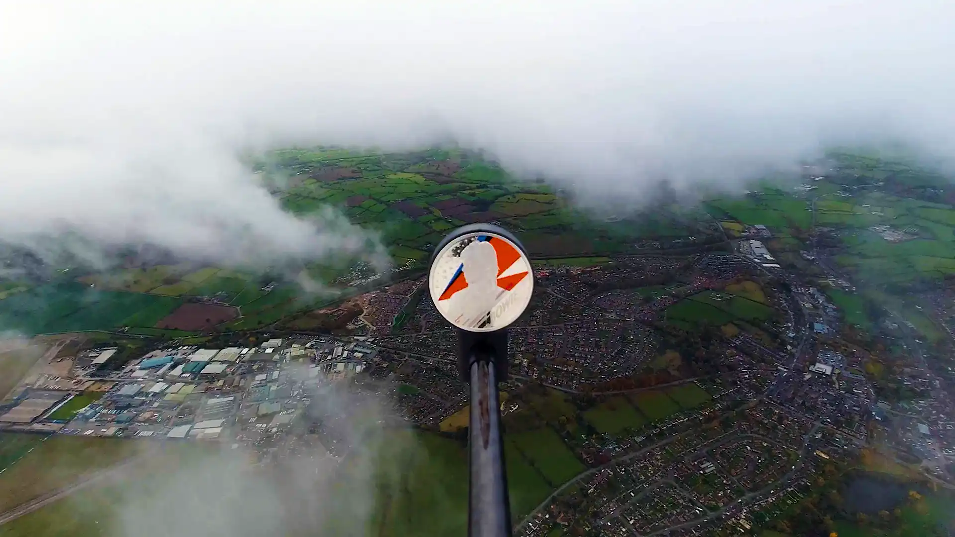 Royal Mint David Bowie coin ascending through the clouds with houses and fields thousands of meters below