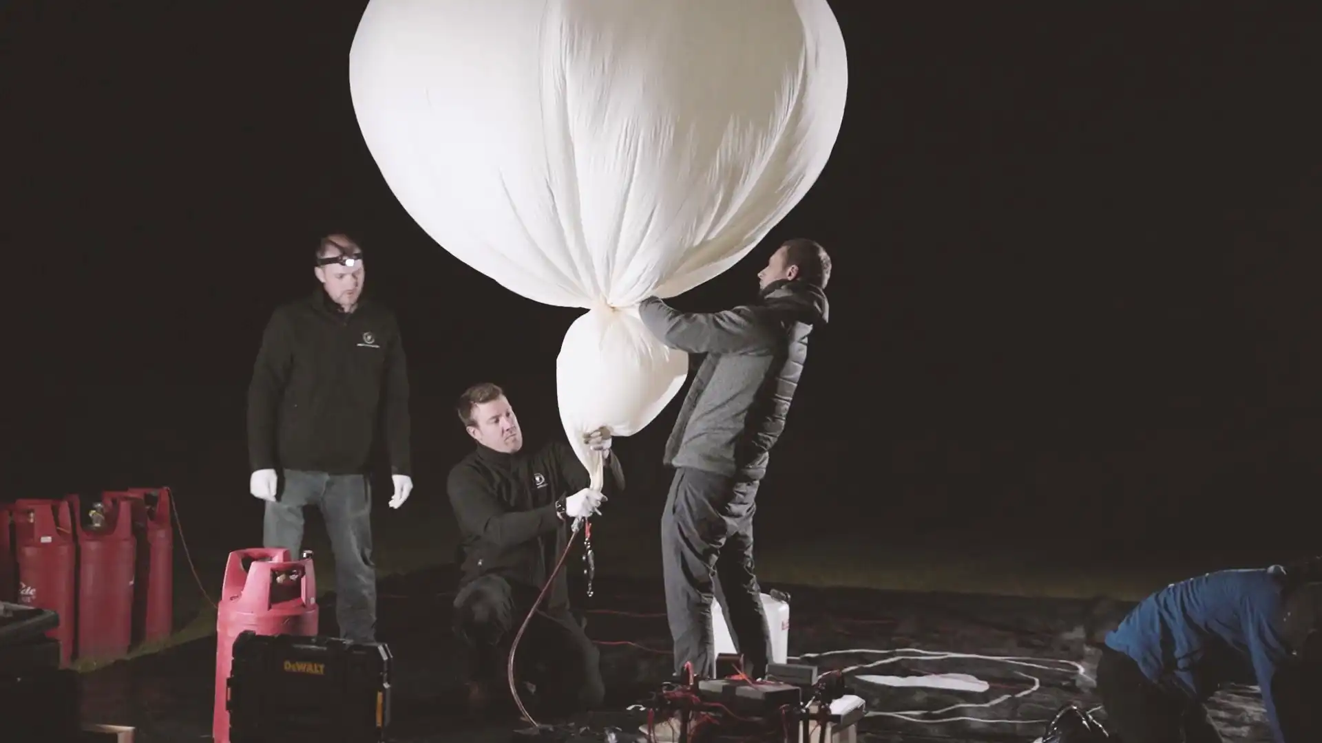 Sent Into Space launch team filling a high-altitude balloon with hyrogen at night