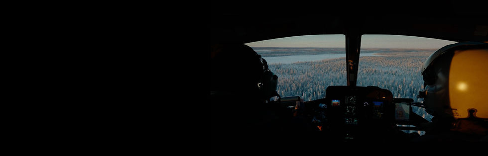 helicopter cockpit with pilot and crew flying helicopter over snowy forest