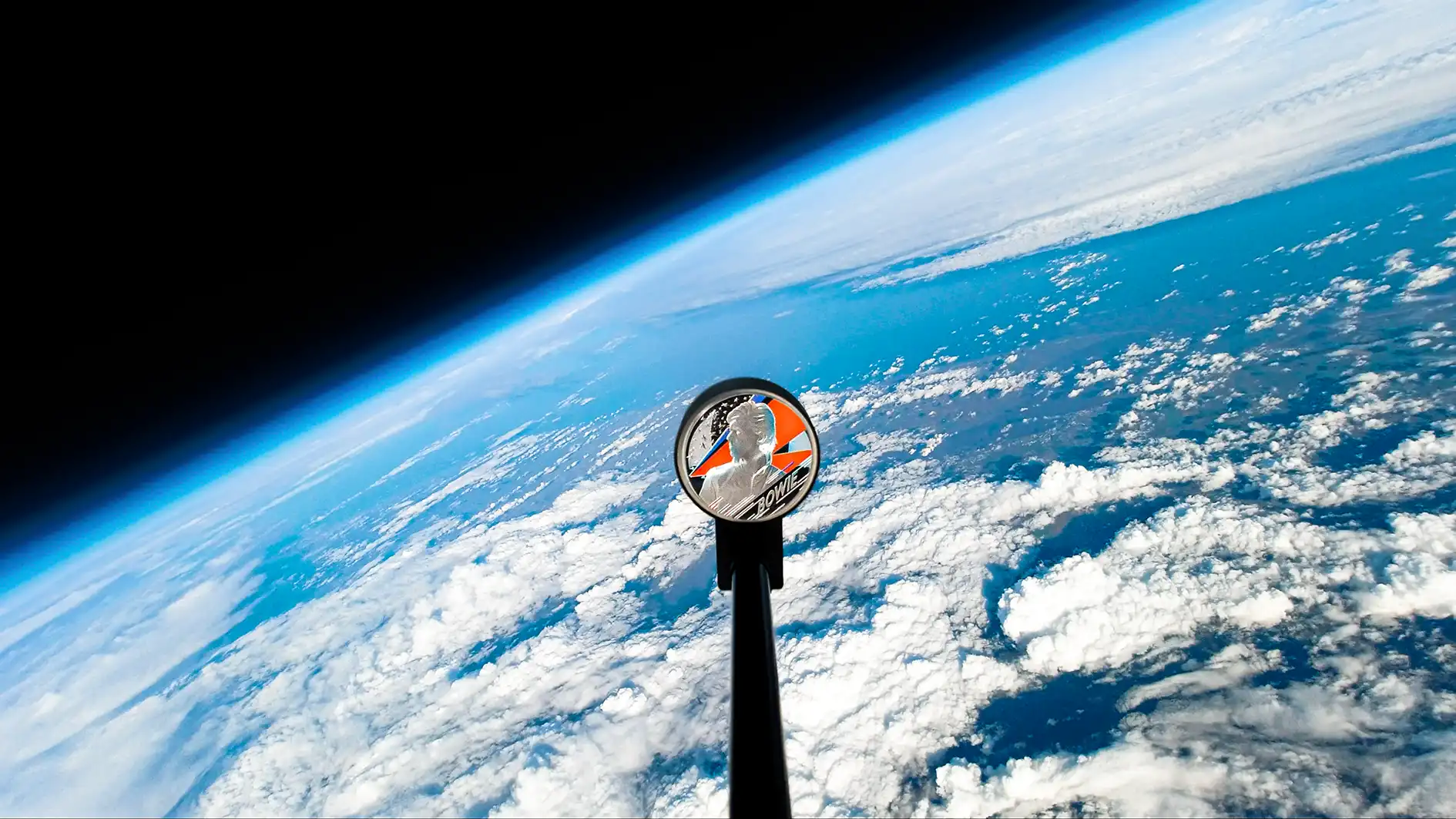 David Bowie Royal Mint coin in space with Earth in the background floating in space