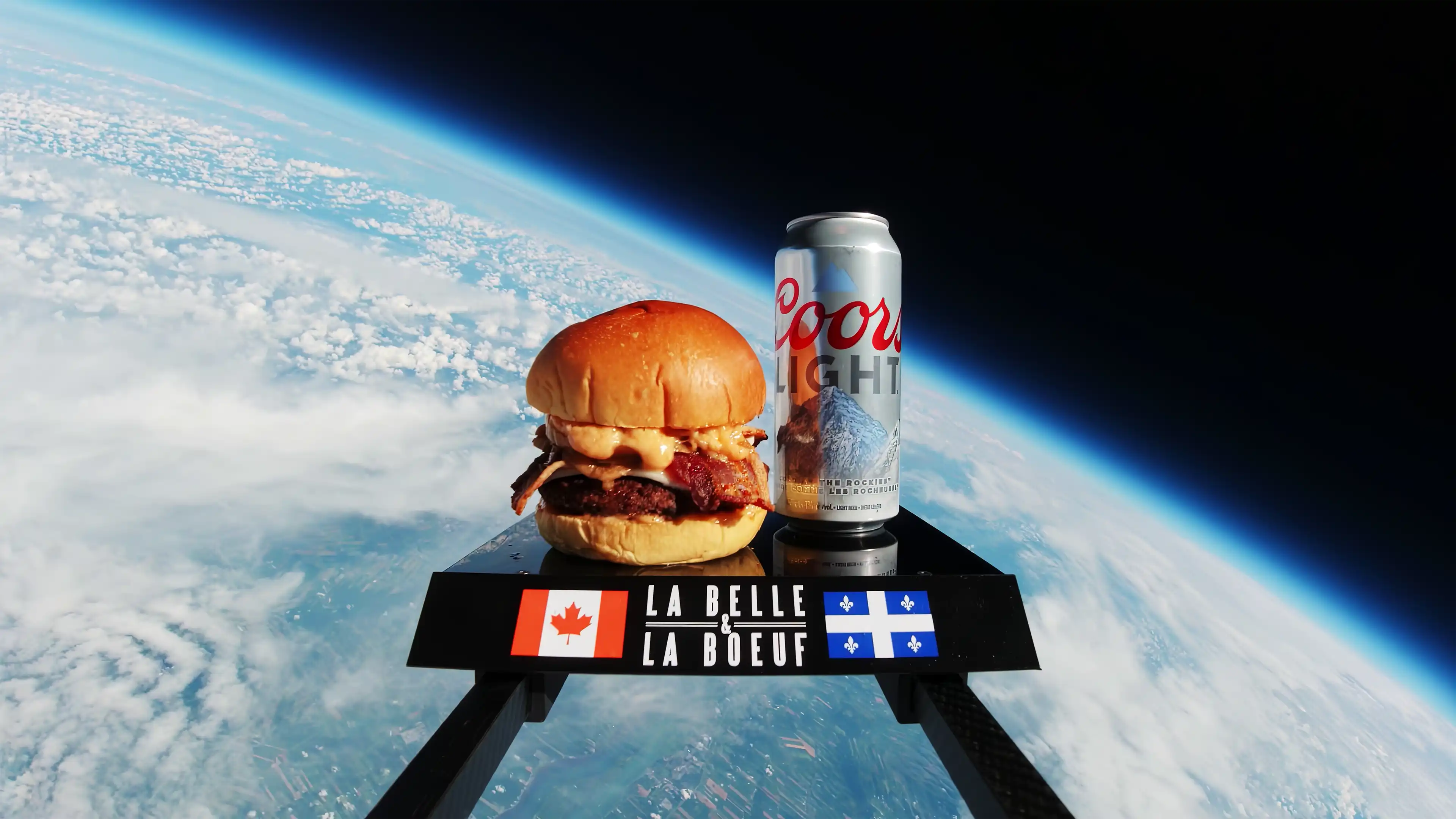 La Belle & La Boeuf burger and can of Coors Light in space