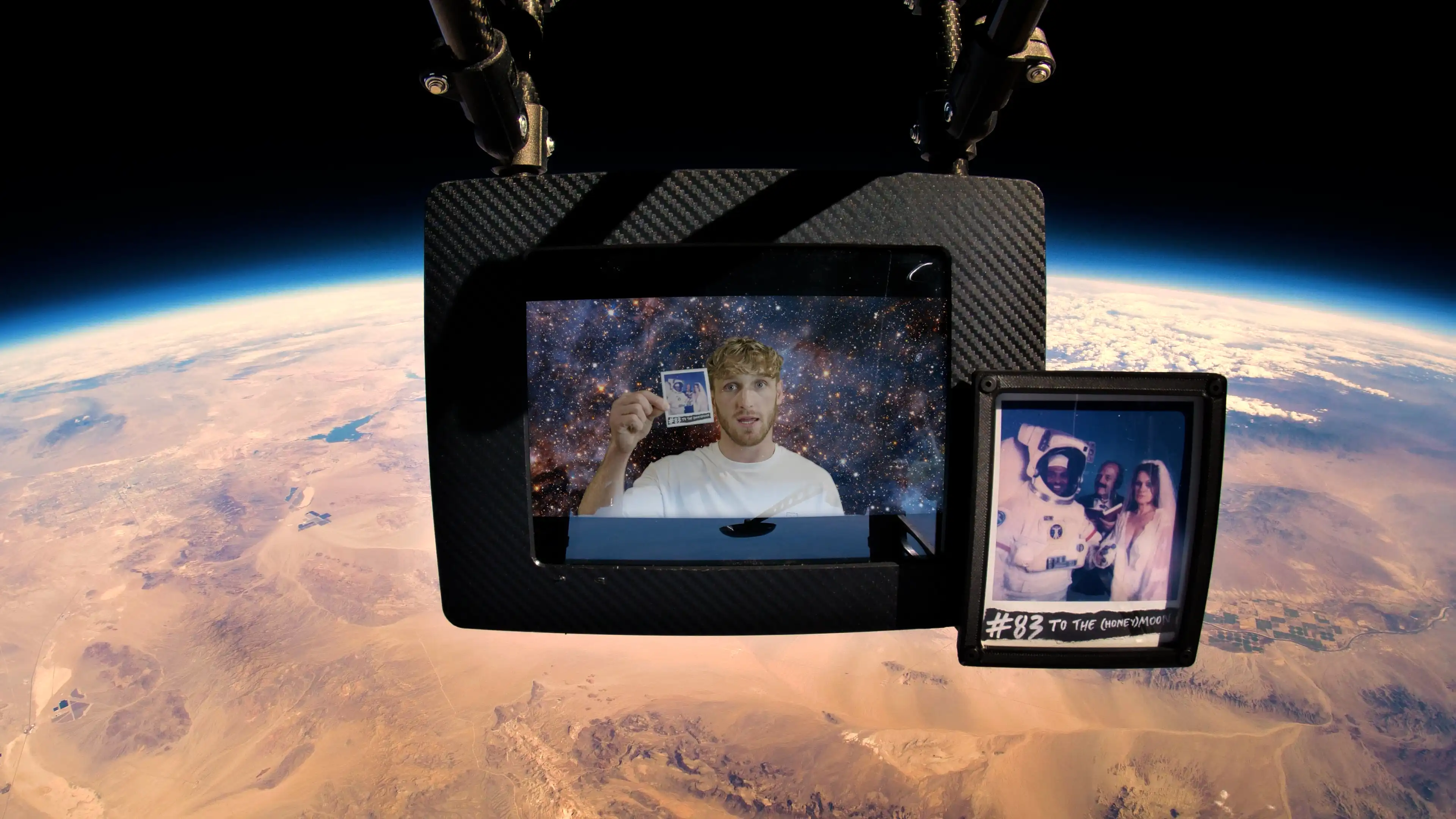 Logan Paul's 99 Originals #83 'TO THE (HONEY) MOON' and a digital screen in space above the arid Nevada Desert.