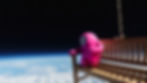 Fall Guys Bean resting on a bench in space with the Earth below