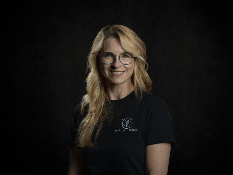 Sent Into Space General Manager, Samantha Richardson, smiling for a portrait with against a black background.