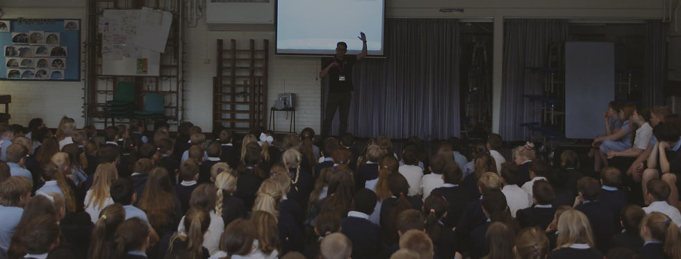 Sent Into Space team member speaking to students in a large assembly room.