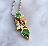 14K gold pendant necklace featuring a fantasy-cut tourmaline with bezel-set tsavorite garnet and diamond accents in a sprout-inspired design.