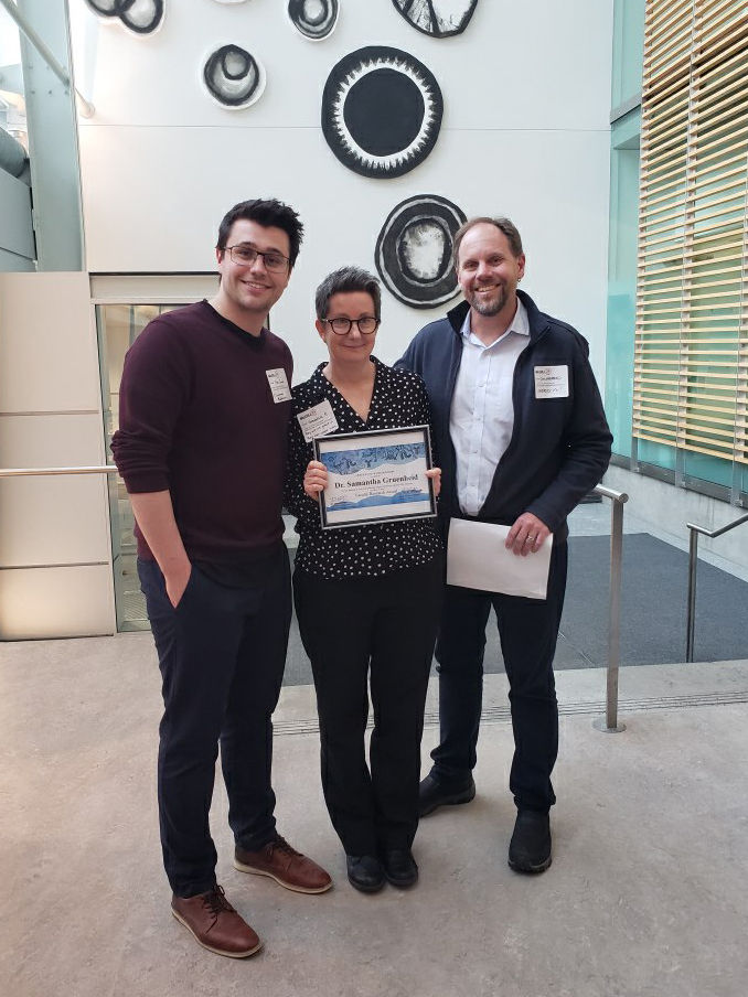 Tyler and Dr. Gruenheid accept their award from Dr. Sheppard, Chair of MIMM