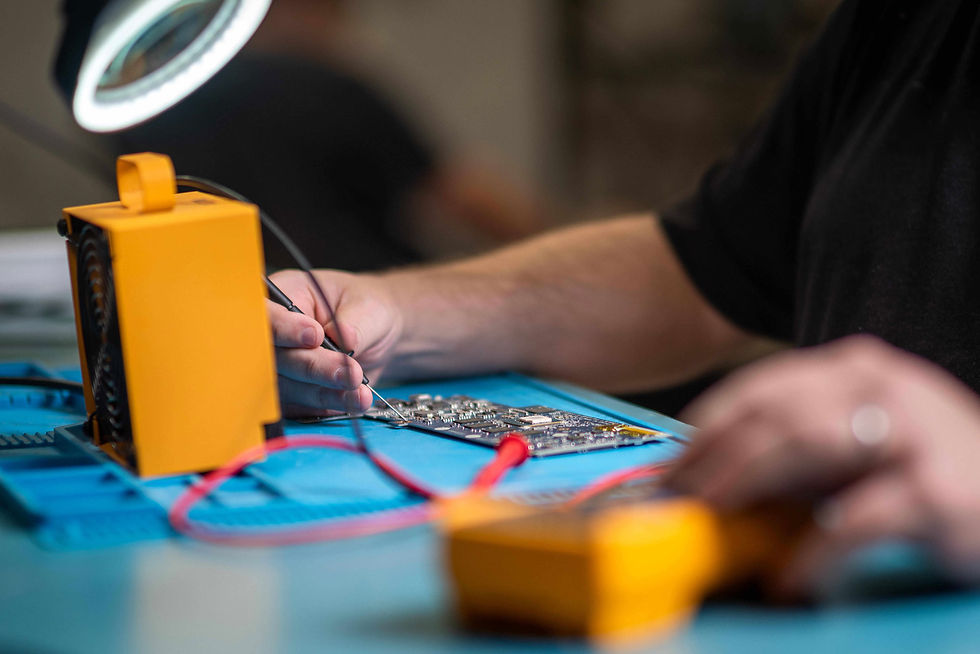 Technician repairing a Chromebook motherboard to help prepare student devices for back-to-school deployment