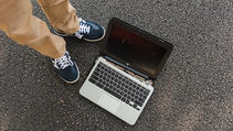 Damaged Chromebook on pavement illustrating common student device damage in schools.