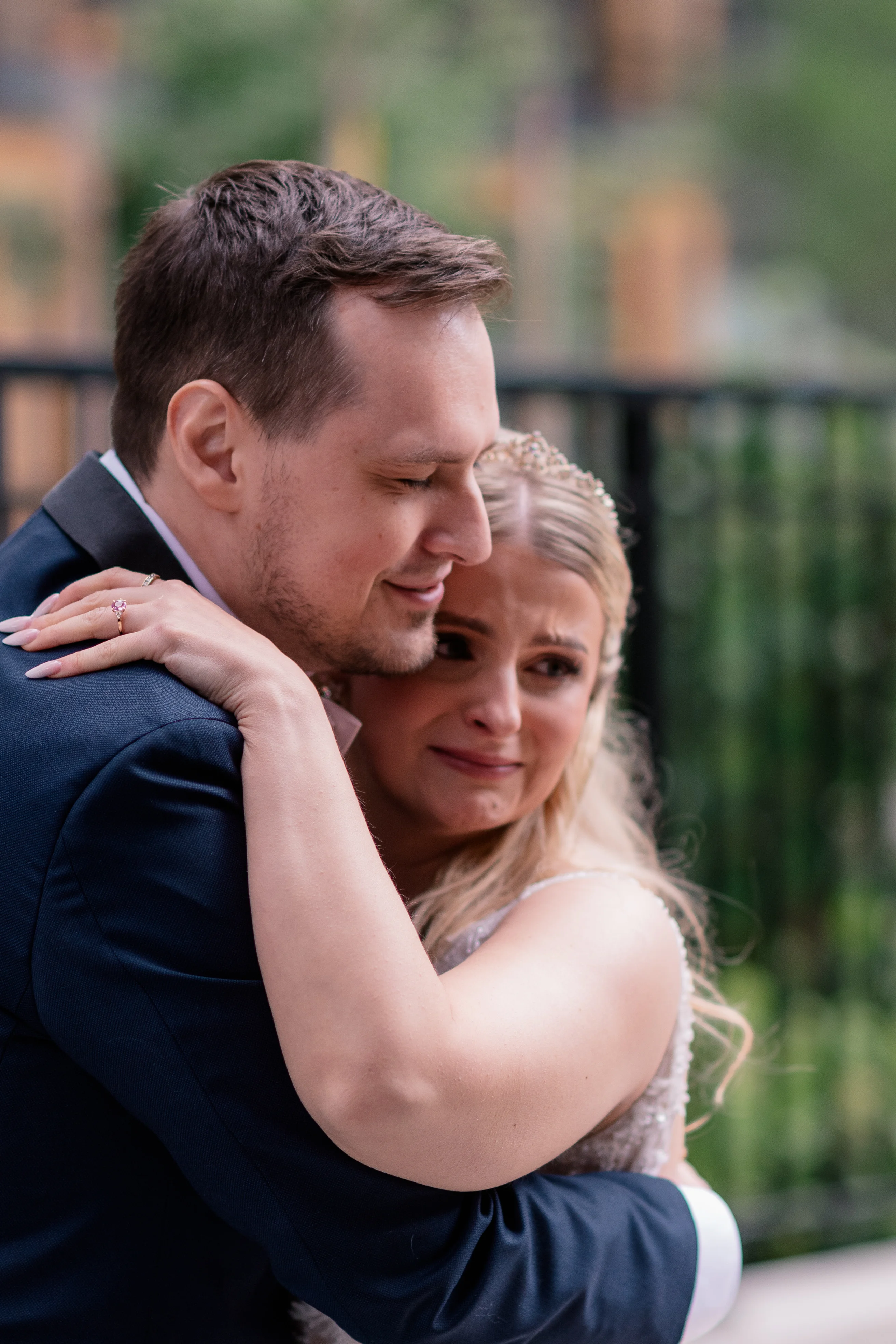 Bride smiling and wiping away tears during the emotional first look with the groom