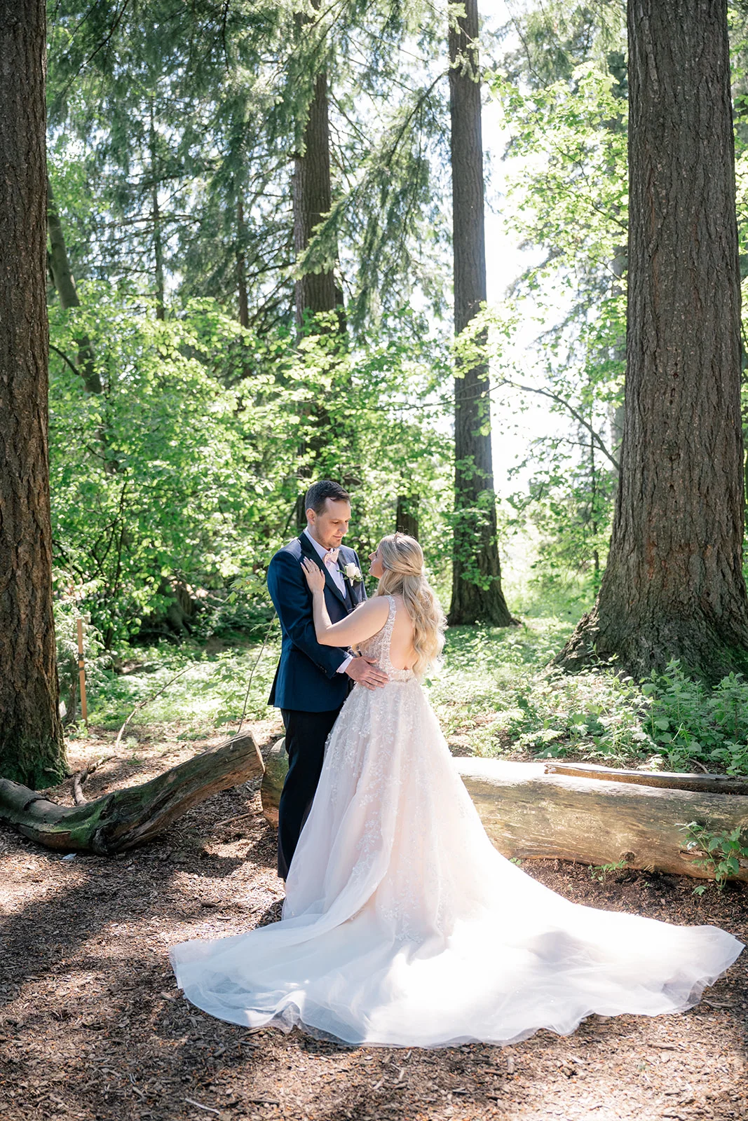 Bride and groom sharing a loving moment amidst the ethereal atmosphere of a forest, capturing the timelessness and wonder of their love story