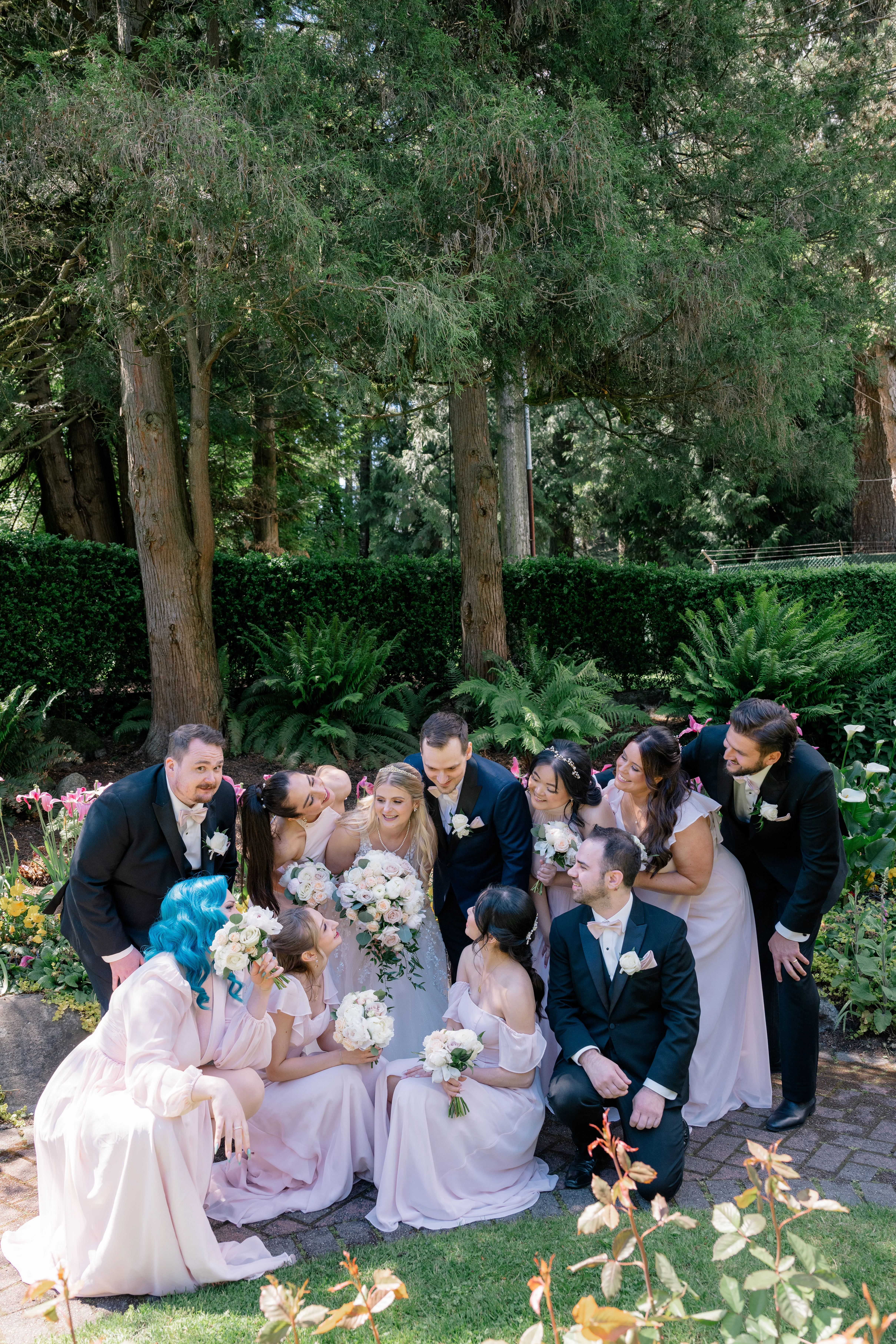 Fun wedding party photos with six bridesmaids in pink and white dresses and three groomsmen in tailored suits, capturing lively and joyous moments.