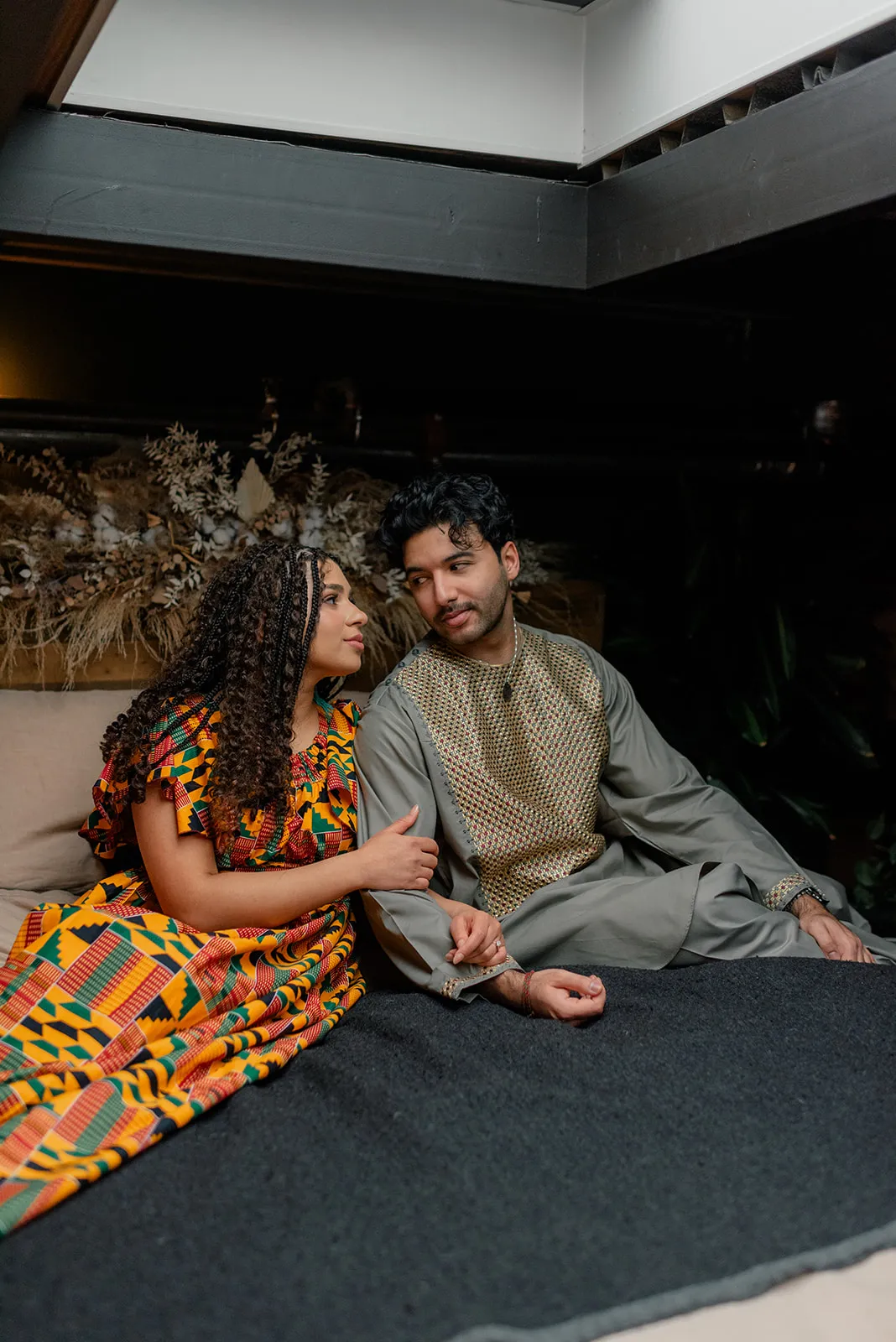 Playful engagement photo of a couple at Loft Garden Oasis in Vancouver, with vibrant greenery and natural light creating a dreamy backdrop.